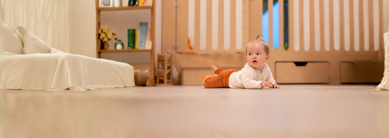 Header   KDV baby op buik spelen kijk naar links