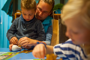 Pedagogisch professional en kind BSO Jump In knutselen